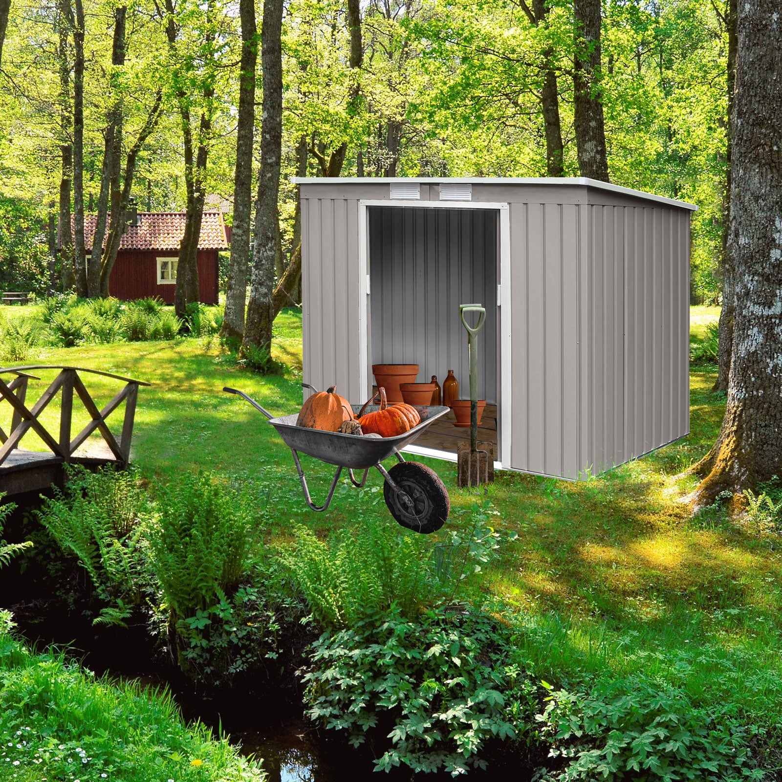 Garten mit grünem Gras, Bäumen und einem kleinen Bach, daneben ein grauer Gartenschuppen mit offenem Eingang und einer Schubkarre mit Kürbissen davor