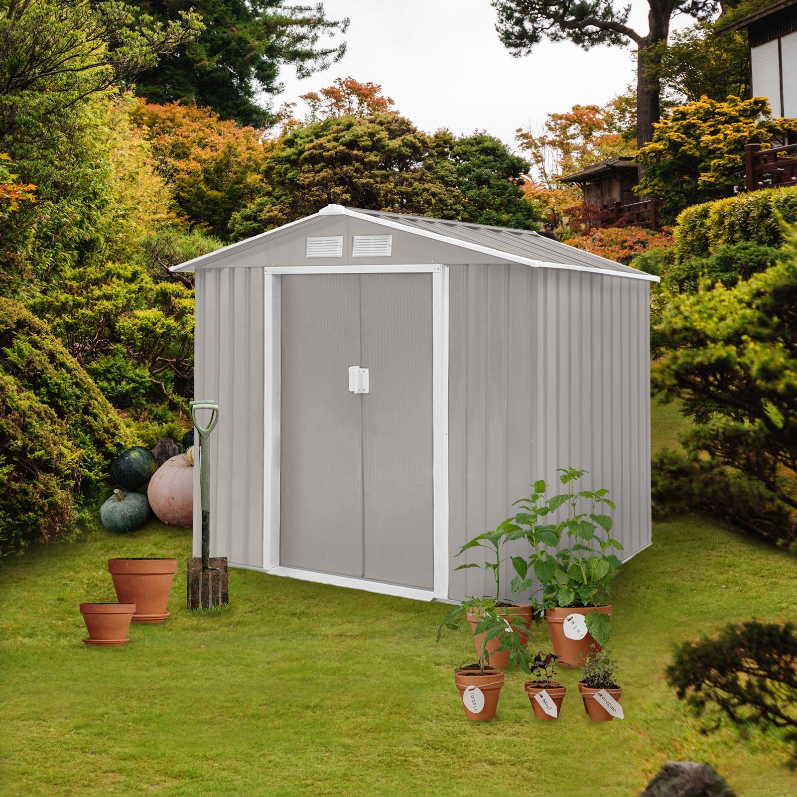 Grauer Metall-Gartenschuppen mit Doppeltür auf grünem Rasen, umgeben von Pflanzen und Gartengeräten